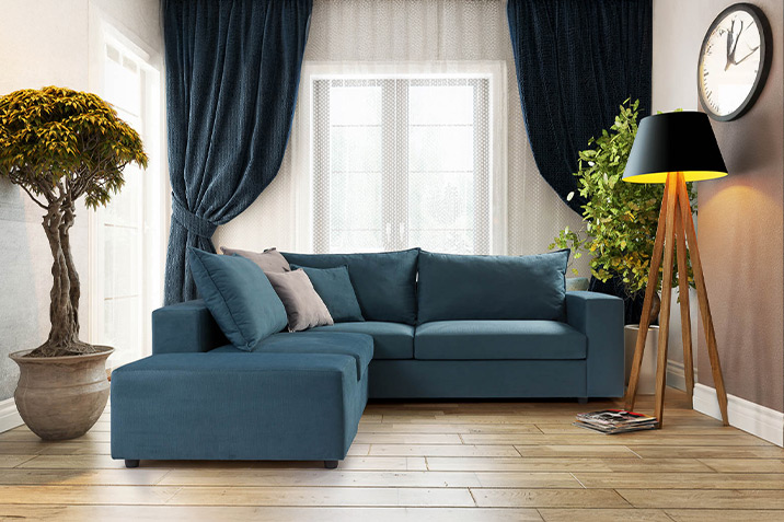 Corner sofa in blue tones with elegant decor and natural elements, by CenterHome.