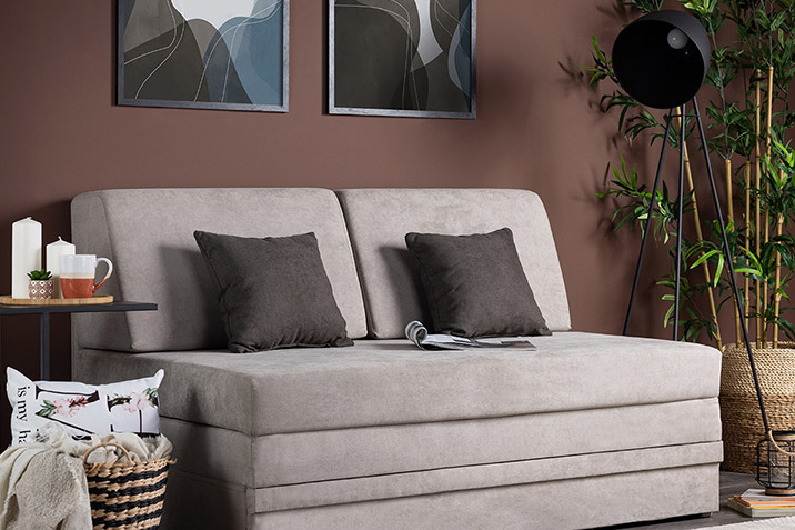 Μικρός μοντέρνος καναπές σε καφέ τοίχο, ιδανικός για μικρούς χώρους με διακοσμητικά φυτά.