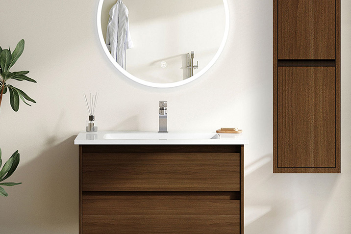 Μοντέρνο έπιπλο μπάνιου με νιπτήρα, στρογγυλό καθρέφτη και ξύλινα στοιχεία σε φυσική απόχρωση.